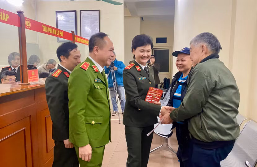 Trung tướng Ngô Thị Hoàng Yến - Cục trưởng Cục Hồ sơ nghiệp vụ (Bộ Công an) và Thiếu tướng Nguyễn Thanh Tùng - Phó Giám đốc CATP Hà Nội trao đổi với những công dân đầu tiên đến làm thủ tục cấp Phiếu lý lịch tư pháp, sáng 1-3-2025