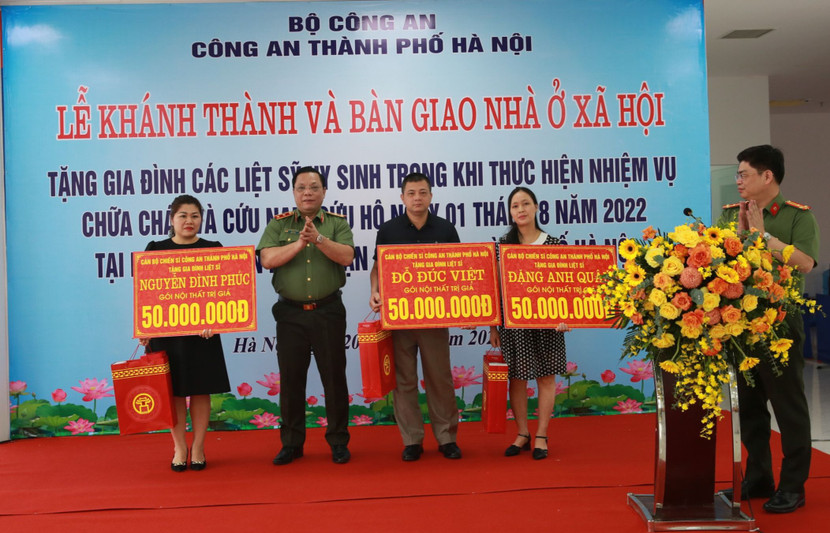 Trung tướng Nguyễn Hải Trung - Ủy viên Ban Thường vụ Thành ủy, Bí thư Đảng ủy, Giám đốc CATP Hà Nội trao quà tặng thân nhân 3 liệt sĩ thuộc CAQ Cầu Giấy, tại buổi lễ bàn giao nhà ở xã hội, ngày 20-7-2023