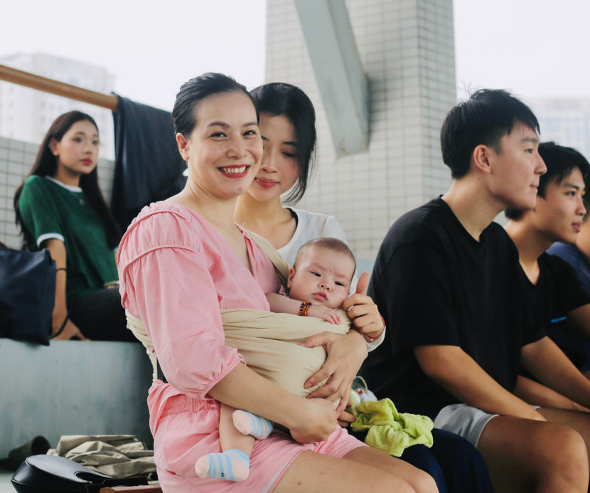 Chị Ngọc Anh cùng con nhỏ và các thành viên khác tới sân, nhiệt tình cổ vũ cho cầu thủ Bùi Quang Tuấn Phát (THPT Kim Liên)