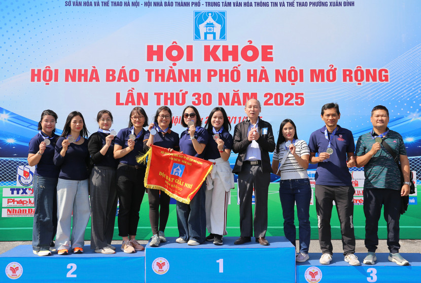 Phó Chủ tịch Thường trực Hội Nhà báo thành phố Hà Nội Kiều Thanh Hùng trao huy chương bạc cho đội kéo co An ninh Thủ đô