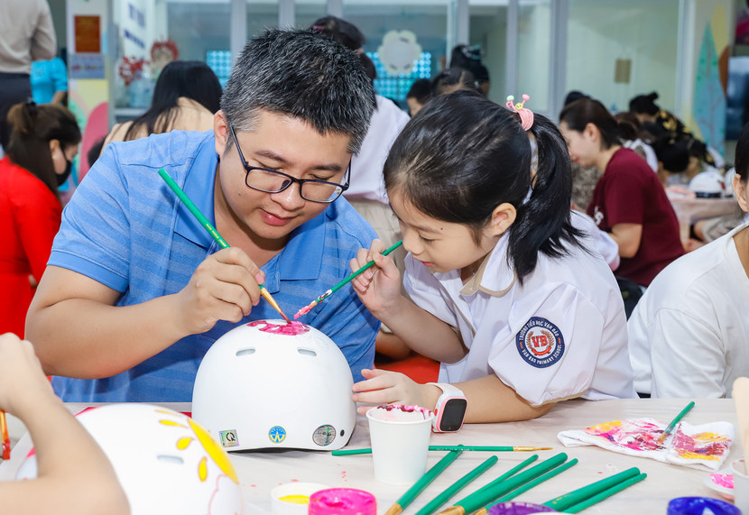 Các em học sinh trang trí mũ bảo hiểm Honda cùng phụ huynh