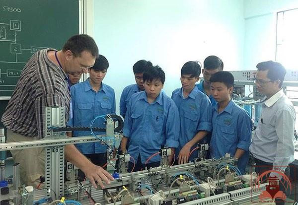 Chuyên gia nước ngoài đang hướng dẫn công nhân Việt Nam vận hành máy móc