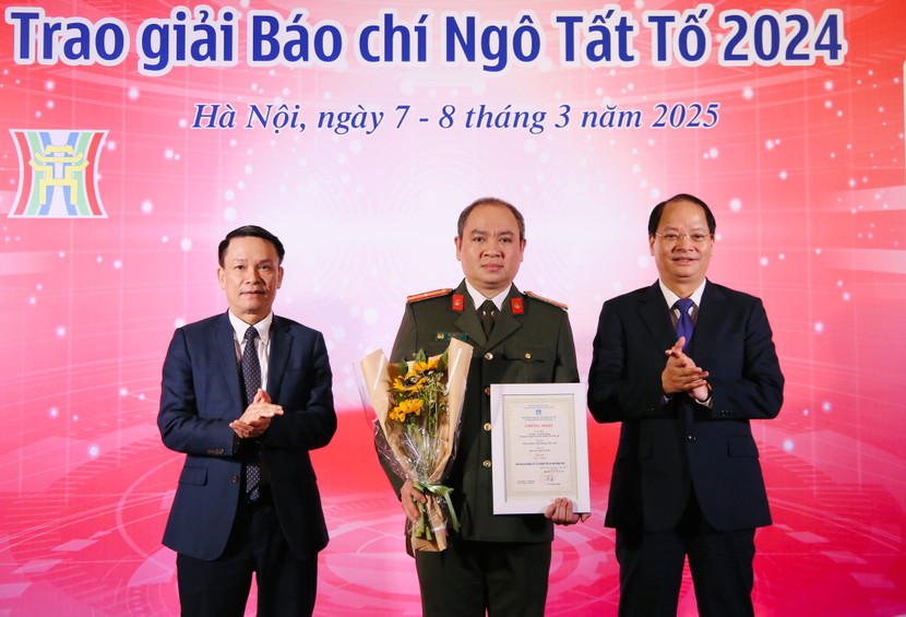 Đồng chí Nguyễn Đức Lợi - Phó Chủ tịch Thường trực Hội Nhà báo Việt Nam (bên trái) và đồng chí Nguyễn Doãn Toản - Ủy viên Ban Thường vụ Thành ủy, Trưởng ban Tuyên giáo và Dân vận Thành ủy Hà Nội (bên phải), trao giải Đặc biệt Giải báo chí Ngô Tất Tố 2024 cho đại diện Nhóm tác giả An ninh Thủ đô
