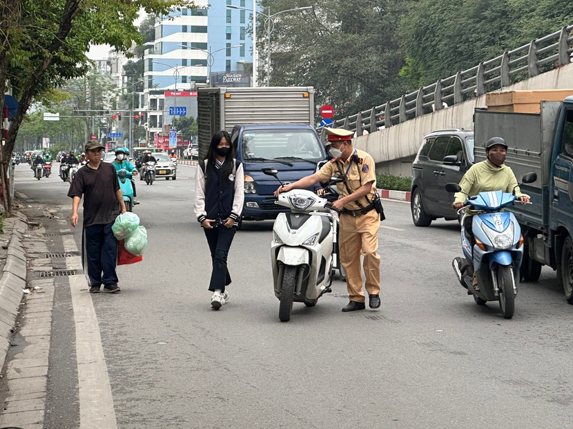 Nữ sinh đi xe máy trên đường đến trường nhưng không đội mũ bảo hiểm