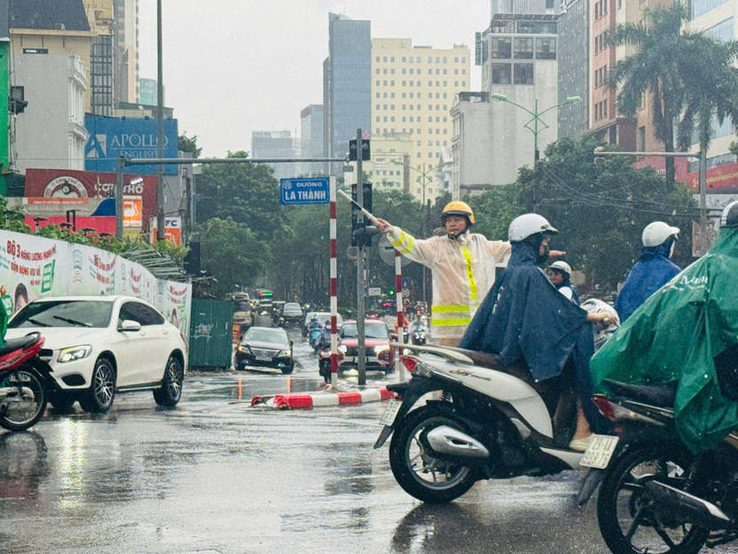 Cảnh sát giao thông Thủ đô dầm mình trong mưa phân luồng, cảnh báo nguy hiểm cho người dân lưu thông an toàn