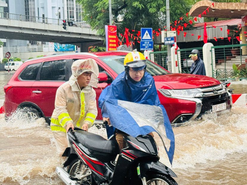 Nhiều phương tiện bị chết máy được Cảnh sát giao thông đưa qua vùng nước ngập