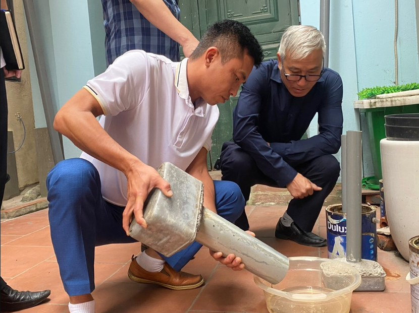 Phó Giám đốc CDC Hà Nội Khổng Minh Tuấn (áo đen) kiểm tra chỉ số bọ gậy tại một ổ dịch SXH