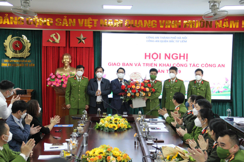 Trung tá Nguyễn Tiến Nam (người thứ 2 bên phải) và cán bộ, chiến sĩ CAQ Bắc Từ Liêm nhận lẵng hoa chúc mừng của lãnh đạo UBND quận về chiến công điều tra khám phá nhanh vụ cướp ngân hàng trên địa bàn