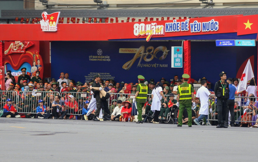 Các chiến sĩ Công an hỗ trợ một người dân bị ngất xỉu khi xem diễu binh diễu hành ở khu vực Quảng trường Cách mạng tháng Tám