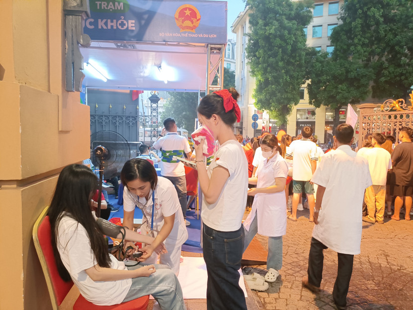 Một người dân gặp vấn đề sức khỏe được nhân viên y tế thăm khám, tại tổ y tế trực ở Nhà hát lớn Hà Nội