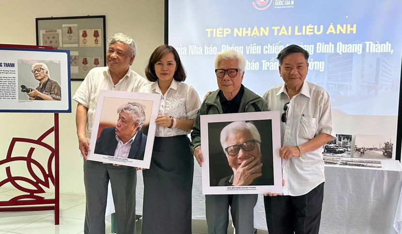 Nhà báo Ngô Minh Đạo (ngoài cùng bên phải) trao tặng Trung tâm Lưu trữ quốc gia III chân dung phóng viên ảnh chiến trường - Đinh Quang Thành và Trần Mai Hưởng.