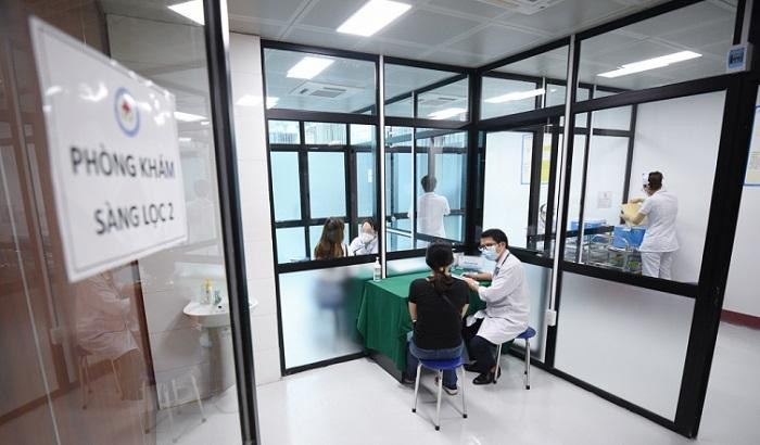 Người dân được khám sàng lọc, tư vấn trước khi vào phòng tiêm vaccine