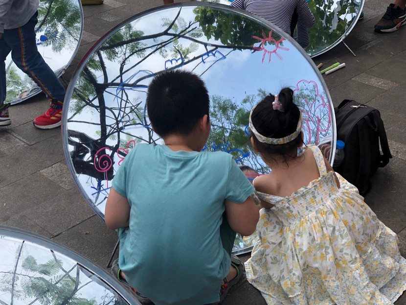 Các em nhỏ vẽ trên gương