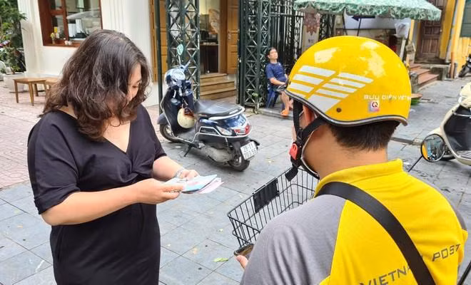 Chị Bùi Kim Dung bày tỏ sự phấn khởi khi được nhận hộ chiếu ngay tại nhà sau khi nộp hồ sơ qua dịch vụ công cấp độ 4
