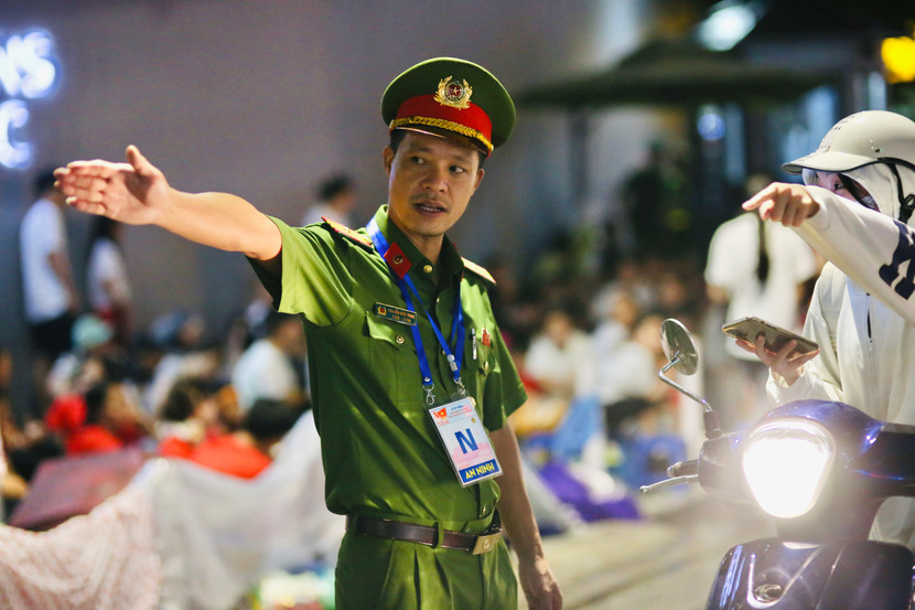 Thiếu tá Nguyễn Đức Thao - cán bộ Phòng Cảnh sát Hình sự, Công an thành phố Hà Nội - giải đáp thắc mắc, hướng dẫn người dân di chuyển trước giờ cấm đường 22h đêm 29-8