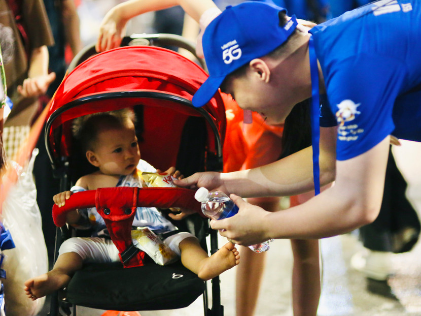 Nguyễn Đức Hải - sinh viên Đại học Công nghiệp Hà Nội - tặng quà một em nhỏ khi cùng gia đình qua khu vực chờ xem tổng duyệt diễu binh