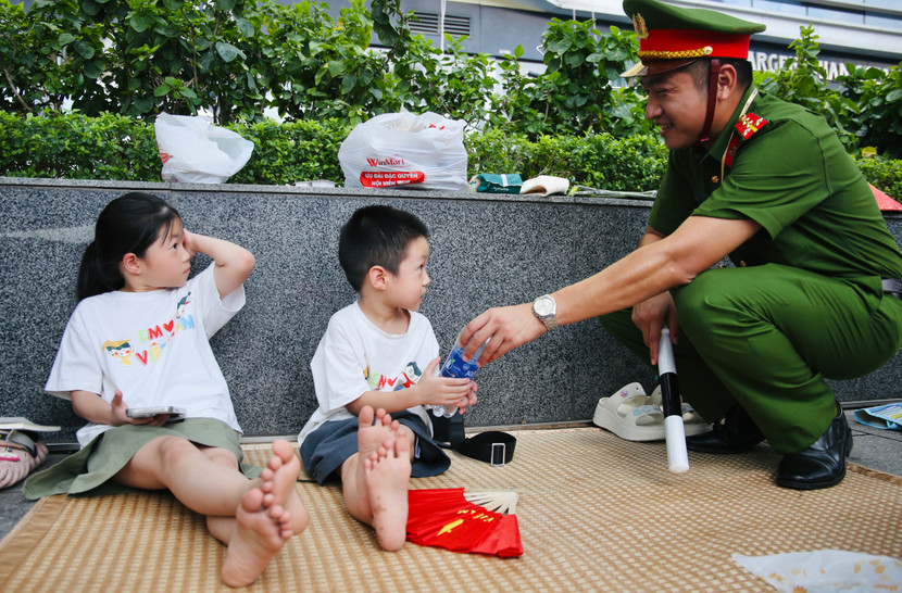 Chai nước mát sau đó được đại úy Đào Duy Đạt tặng lại cho một cháu bé đang cùng gia đình chờ xem diễu binh