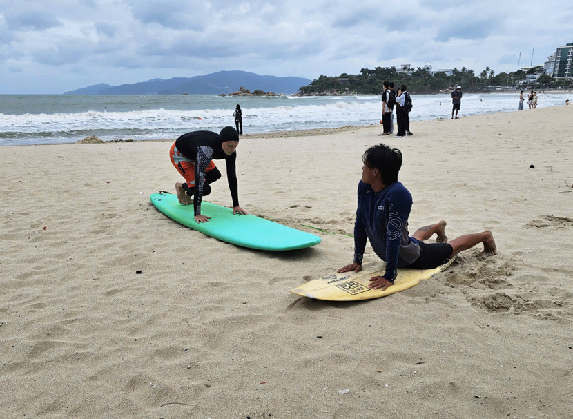 Du khách tập các kỹ năng lướt sóng trên bờ biển Nha Trang.