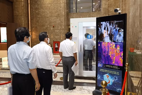 Các đại biểu đo thân nhiệt và bước qua buồng khử khuẩn tự động Các đại biểu đo thân nhiệt và bước qua buồng khử khuẩn tự động