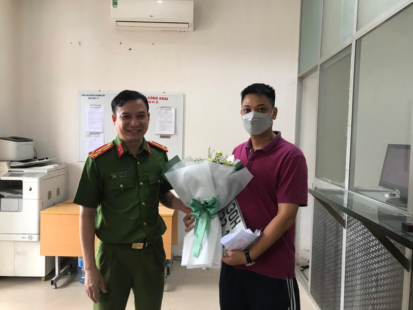 Chỉ huy CAH Chương Mỹ tặng hoa, chúc mừng công dân đầu tiên hoàn tất làm thủ tục đăng ký phương tiện