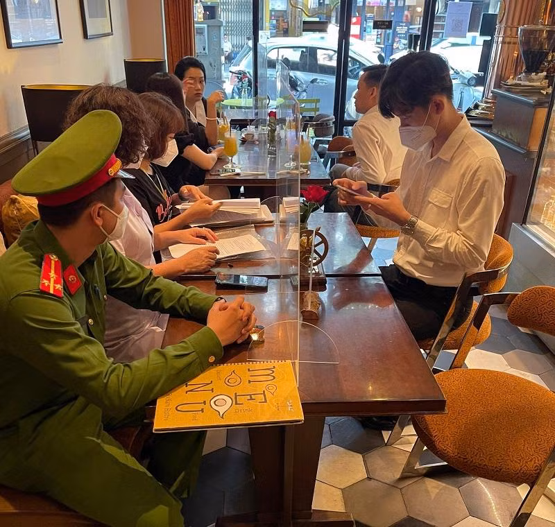 Lực lượng chức năng kiểm tra việc thực hiện quy định về quét mã QR tại phường Hàng Trống, quận Hoàn Kiếm
