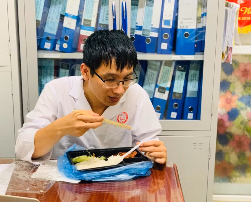 Anh Đặng Đình Nguyên - cán bộ Phòng Nhập liệu (CDC Bắc Giang) và hộp cơm ăn vội lúc nửa đêm