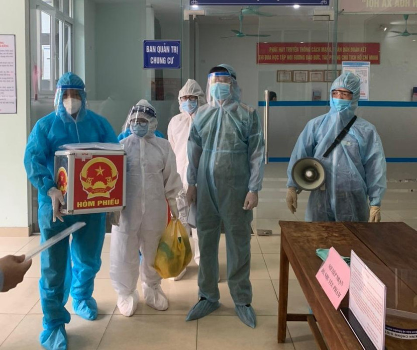 Lực lượng Công an Hà Nội và nhân viên y tế mang hòm phiếu vào trong khu cách ly để cử tri bỏ phiếu Lực lượng Công an Hà Nội và nhân viên y tế mang hòm phiếu vào trong khu cách ly để cử tri bỏ phiếu