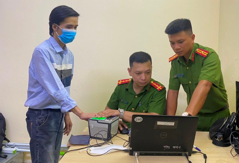 Thiếu tá Hoàng Anh Trung - Trưởng CAP Phan Chu Trinh, quận Hoàn Kiếm, Hà Nội (ngoài cùng bên phải) hướng dẫn đồng đội làm thủ tục cấp Căn cước công dân gắn chíp cho người dân