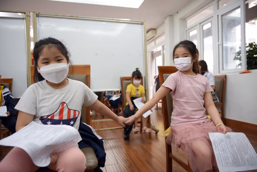 Các em học sinh tiểu học ở Hà Nội trong phòng chờ đến lượt tiêm vaccine Covid-19