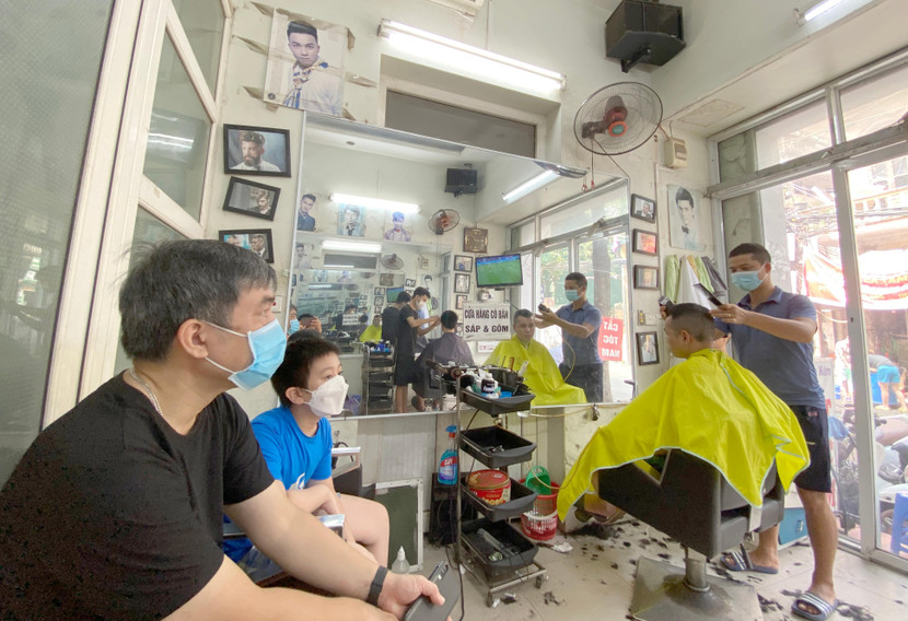 Các cửa hàng cắt tóc ở Hà Nội hoạt động trở lại sau gần 1 tháng dịch vụ này phải tạm dừng để phòng chống dịch Covid-19 - Ảnh: LAM THANH
