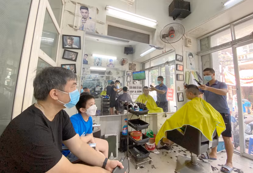 Các cửa hàng cắt tóc ở Hà Nội hoạt động trở lại sau gần 1 tháng dịch vụ này phải tạm dừng để phòng chống dịch Covid-19 - Ảnh: LAM THANH