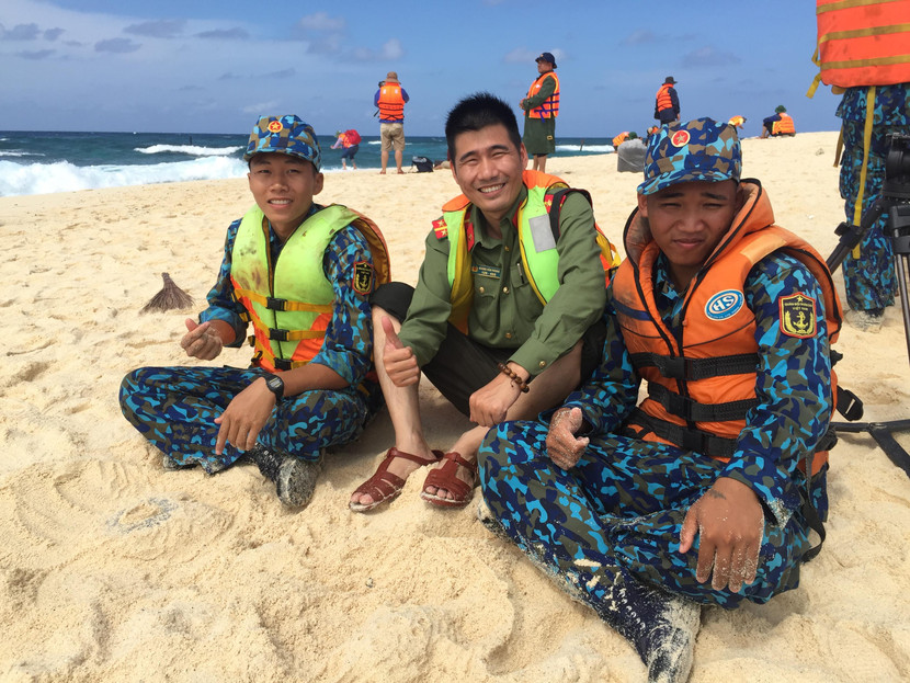 Phóng viên Báo An ninh Thủ đô (ở giữa) cùng các chiến sĩ hải quân nghỉ ngơi trong khi chờ kéo xuồng đưa hàng Tết vào đảo An Bang