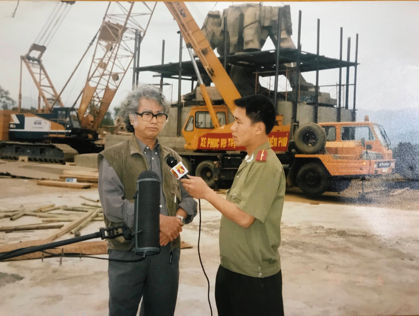 Tác giả phỏng vấn họa sĩ Lê Hiệp (bên trái) tại chân Tượng đài chiến thắng Điện Biên Phủ năm 2004