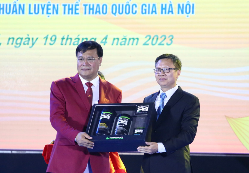Trưởng đoàn thể thao Việt Nam - Đặng Hà Việt (trái) nhận quà tượng trưng từ ông Vũ Văn Thắng - Tổng giám đốc Herbalife Việt Nam và Campuchia