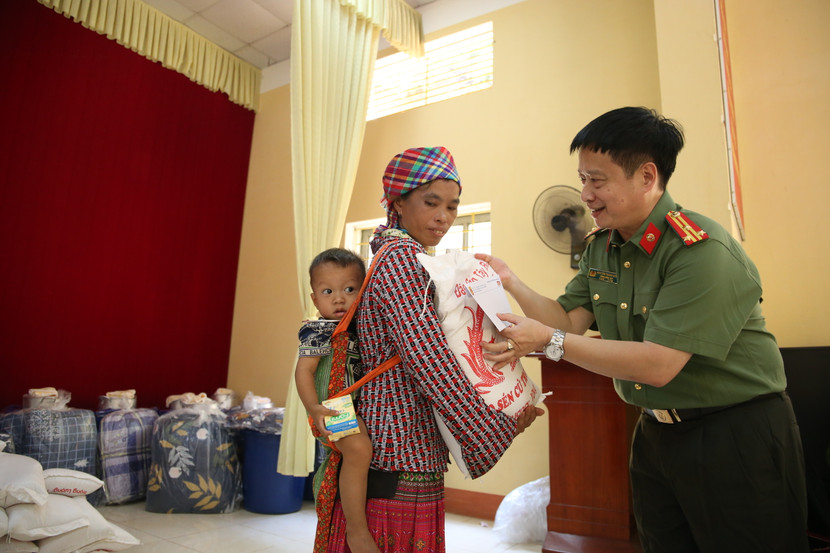 Thượng tá Nguyễn Thanh Bình - Trưởng ban Biên tập An ninh Thủ đô, Trưởng đoàn công tác Báo An ninh Thủ đô trao quà cho gia đình chị Giàng Thị Công (43 tuổi, thôn Khe Đâm)