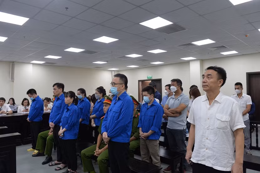 Bị cáo Trần Hùng (áo trắng, ngoài cùng, bên phải) và các bị cáo liên quan tại phiên tòa sơ thẩm. Bị cáo Trần Hùng (áo trắng, ngoài cùng, bên phải) và các bị cáo liên quan tại phiên tòa sơ thẩm.