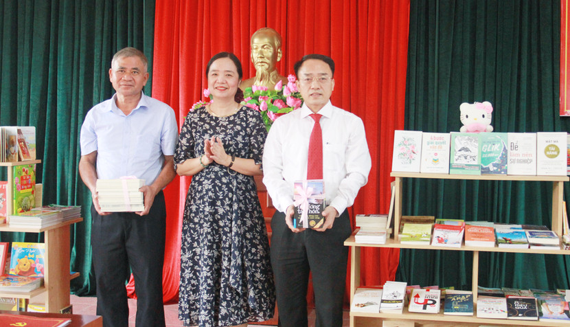 Vụ trưởng Vụ Thư viện Bộ VH-TT&amp;DL Vũ Dương Thúy Ngà trao tặng tủ sách cho đại diện xã Đồng Tâm