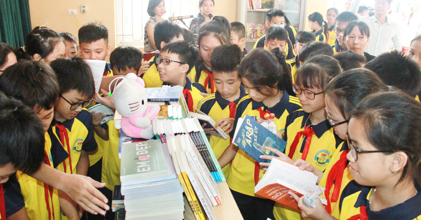 Các em học sinh thích thú khám phá tủ sách