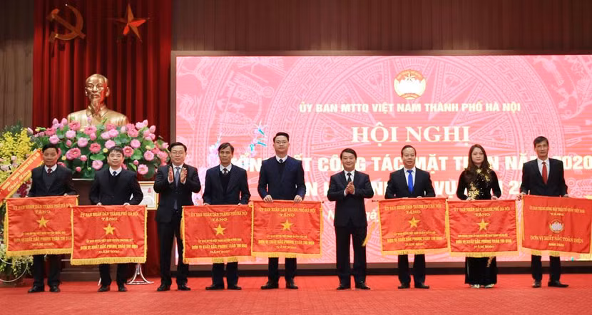 Ủy viên Bộ Chính trị, Bí thư Thành ủy Hà Nội Vương Đình Huệ và Phó Chủ tịch, Tổng Thư ký Ủy ban Trung ương Mặt trận Tổ quốc Việt Nam Hầu A Lềnh trao Cờ đơn vị xuất sắc phong trào thi đua năm 2020 cho các tập thể