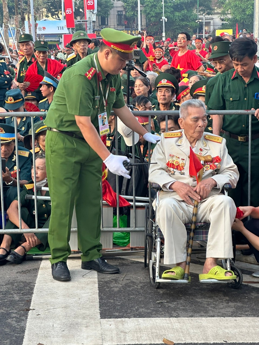 Đại úy Nguyễn Nguyễn Tiến Quang - Phó Trưởng Công an phường Ba Đình giúp một cựu chiến binh vào khu vực ưu tiên xem lễ diễu binh, diễu hành Kỷ niệm 80 năm Cách mạng tháng Tám và Quốc khánh 2-9