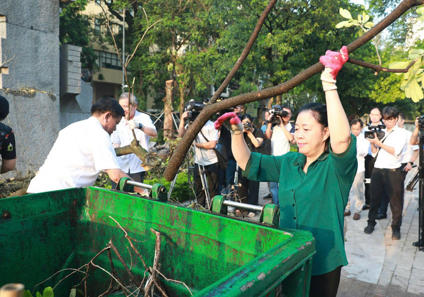 Bí thư Thành ủy Bùi Thị Minh Hoài tham gia dọn cành cây cùng người dân tại Vườn hoa Vạn Xuân (Ảnh: Viết Thành)
