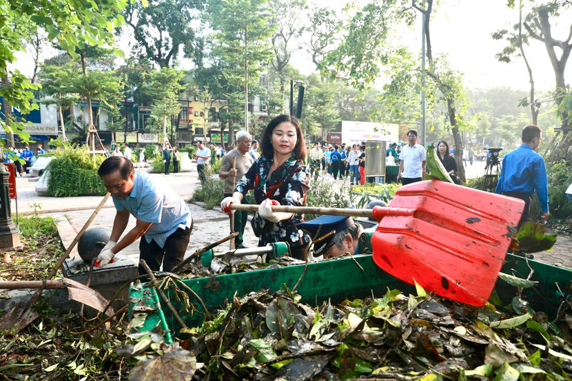 Phó Bí thư Thường trực Thành ủy Nguyễn Thị Tuyến tham gia vệ sinh môi trường cùng người dân tại Vườn hoa Vạn Xuân (Ảnh: Viết Thành)