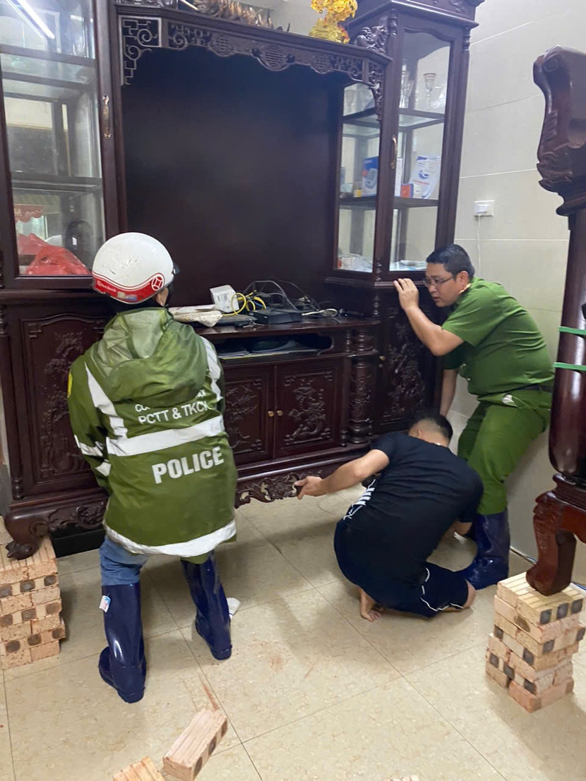 Công an phường hỗ trợ người dân kê cao đồ đạc, bảo vệ tài sản trước khi dời khỏi nơi sinh sống