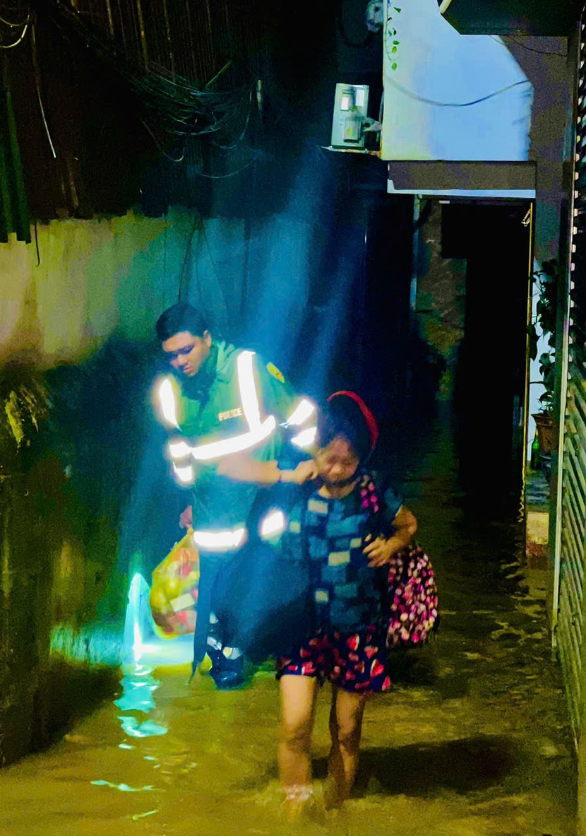 Cán bộ chiến sĩ hỗ trợ đưa người già và trẻ nhỏ đến nơi an toàn trước