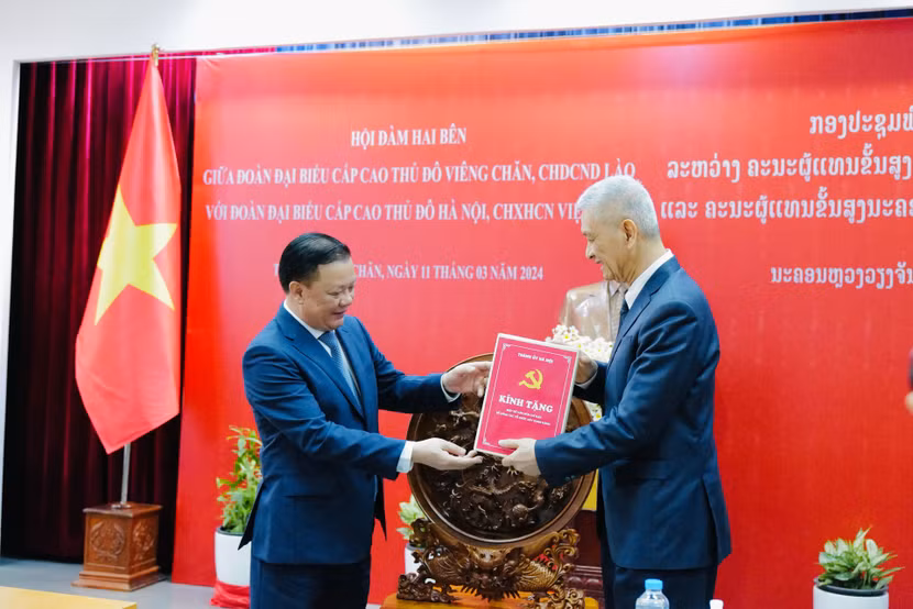 Bí thư Thành ủy Hà Nội Đinh Tiến Dũng trao tặng Thành ủy Viêng Chăn bộ tài liệu tham khảo về công tác xây dựng Đảng và hệ thống chính trị