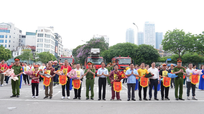 Các đại biểu trao hoa và cờ lưu niệm chúc mừng 8 đội tham gia Hội thi Tổ liên gia an toàn PCCC