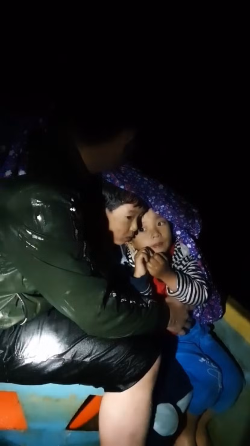 Hình ảnh xúc động khi hai em nhỏ được CAX Quảng Hòa, thị xã Ba Đồn dùng ca nô đưa khỏi vùng ngập sâu