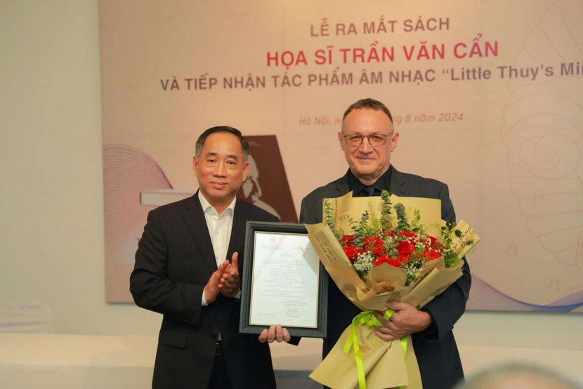 Giám đốc Bảo tàng Mỹ thuật Việt Nam Nguyễn Anh Minh tặng hoa và thư cảm ơn cho nhạc sỹ Paul Zetter - tác giả tác phẩm âm nhạc “Little Thuy's Minuet". Ảnh: Bảo tàng Mỹ thuật Việt Nam