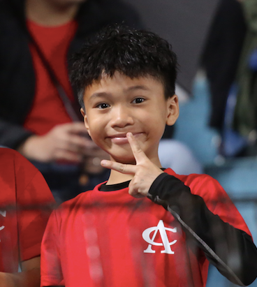 Một cổ động viên nhỏ tuổi mặc trên mình áo cổ vũ CLB Công an Hà Nội, nhí nhảnh trước ống kính