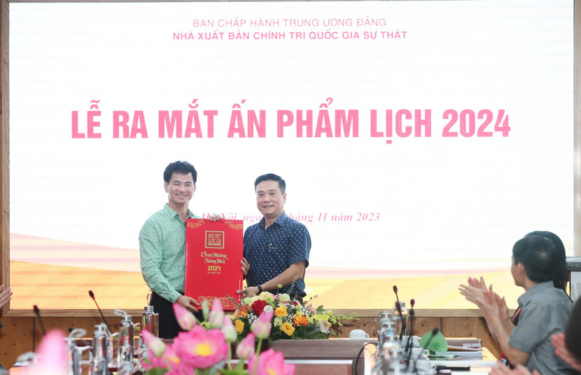 Phó Giám đốc Nhà xuất bản Chính trị quốc gia Sự thật Nguyễn Thái Bình tặng lịch cho NSƯT Xuân Bắc.